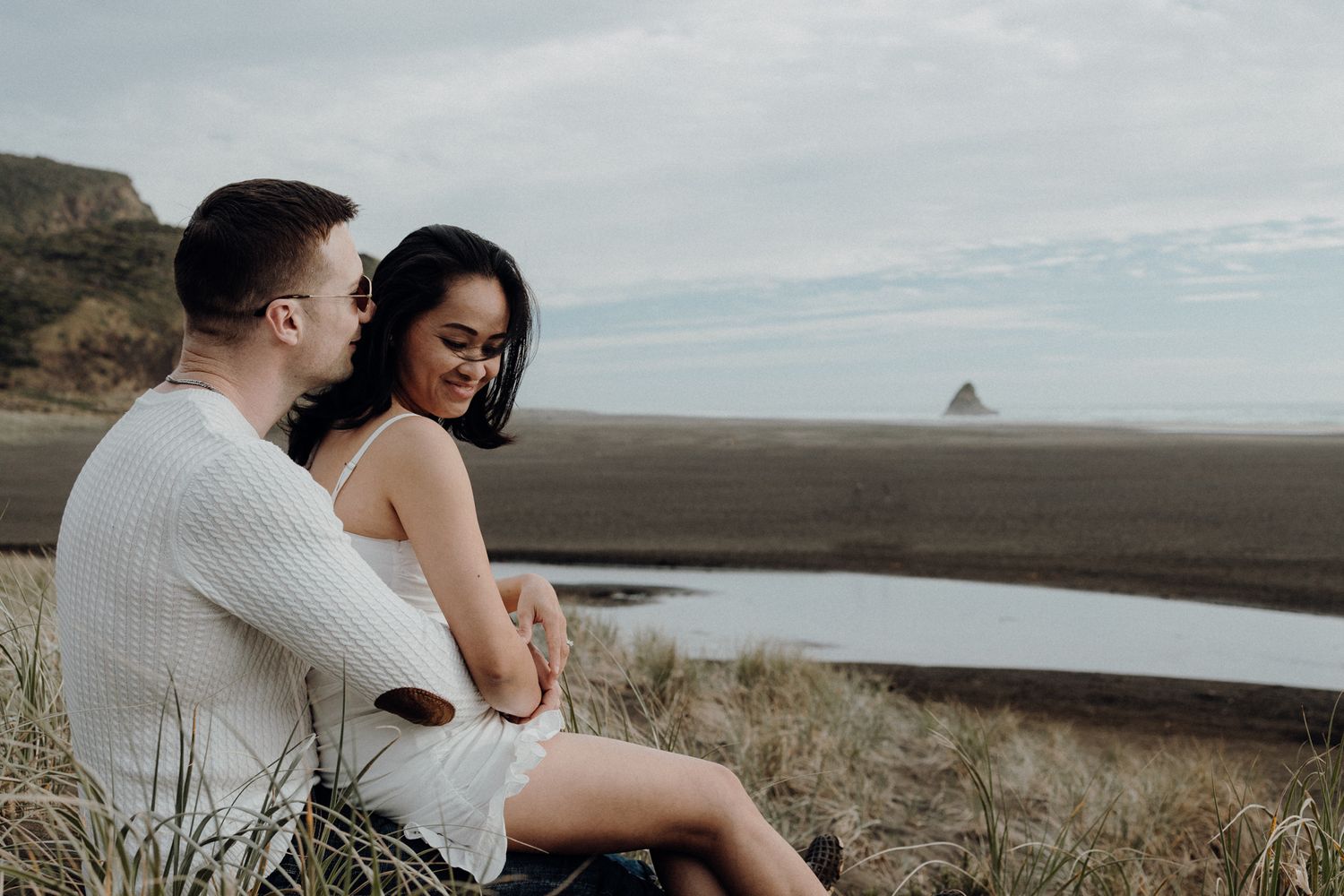 A couple in Karekare Beach sitting in their post-wedding shoot with Apertured Media-Auckland Wedding Photographer.