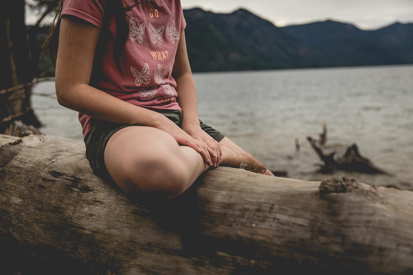 girl sitting on log next to Cle Elum Lake