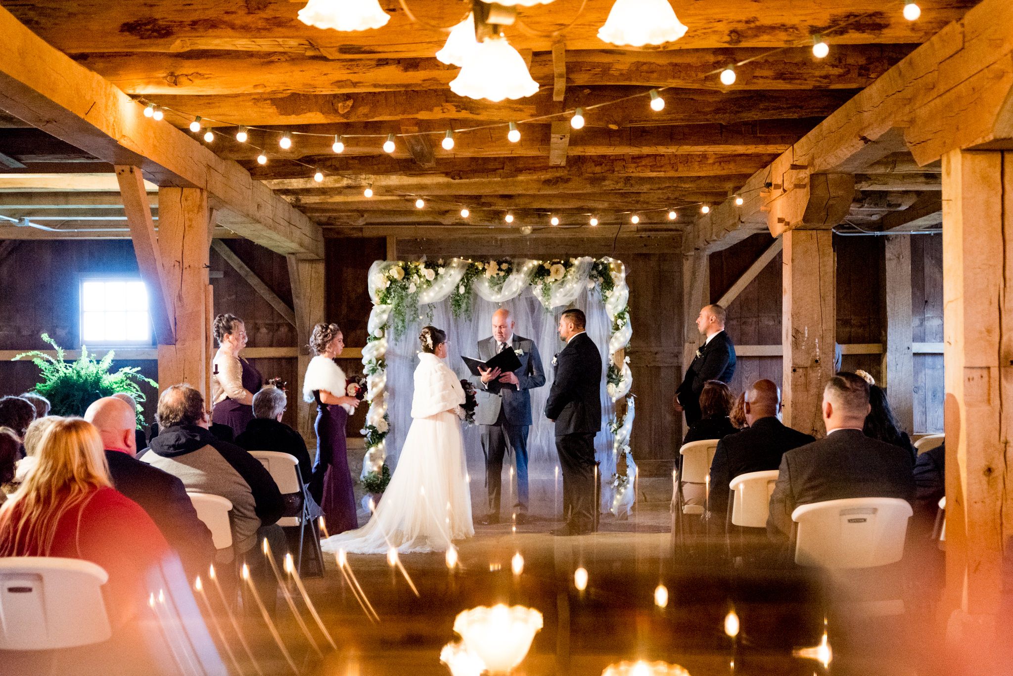 bride and groom standing at the alter in barn