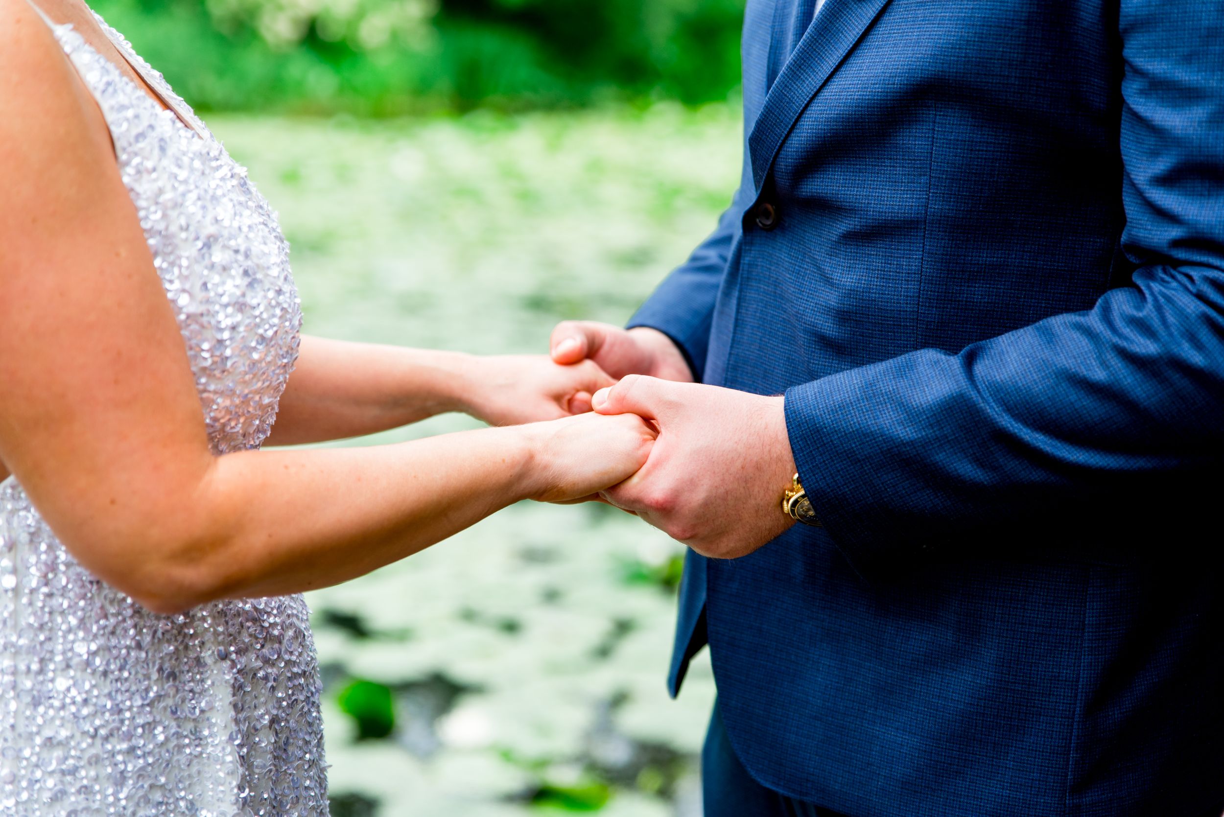 couple holding hands during vows at Alfred Caldwell Lily Pool summer elopement Chicago