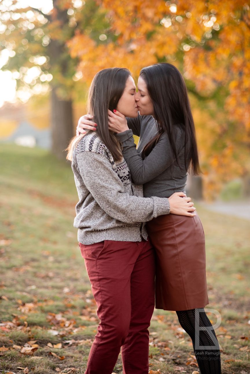 Women kiss in autumn, New England fall foliage in Medford, MA