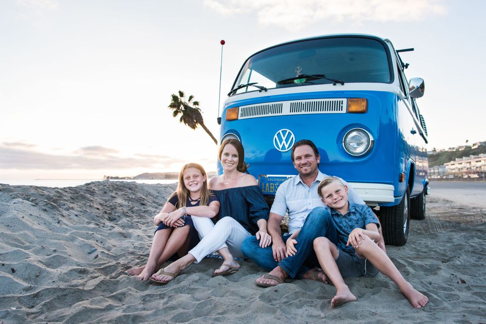 Photo of a family in front of a VW Bus on the beach in Orange County, CA