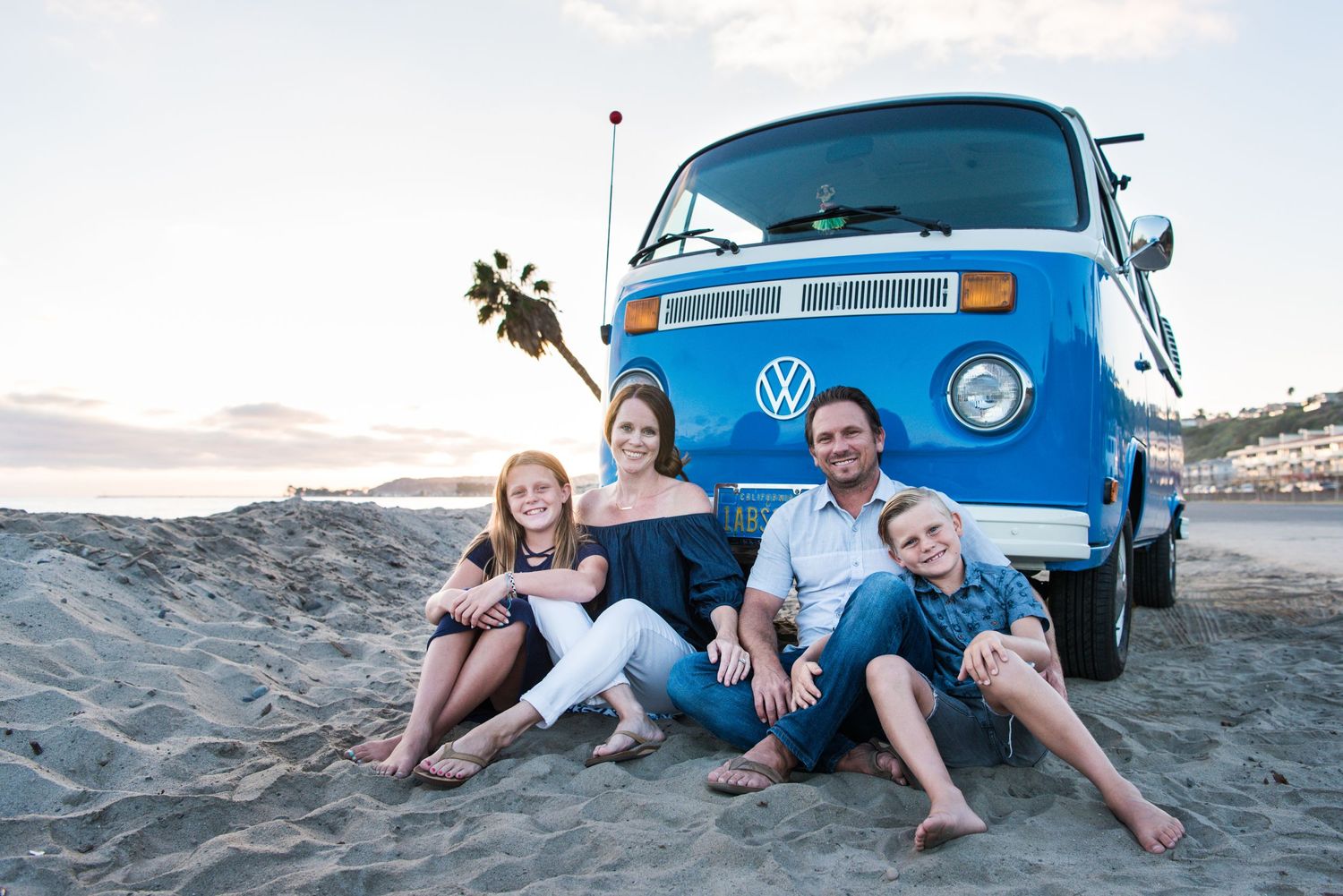 Photo of a family in front of a VW Bus on the beach in Orange County, CA