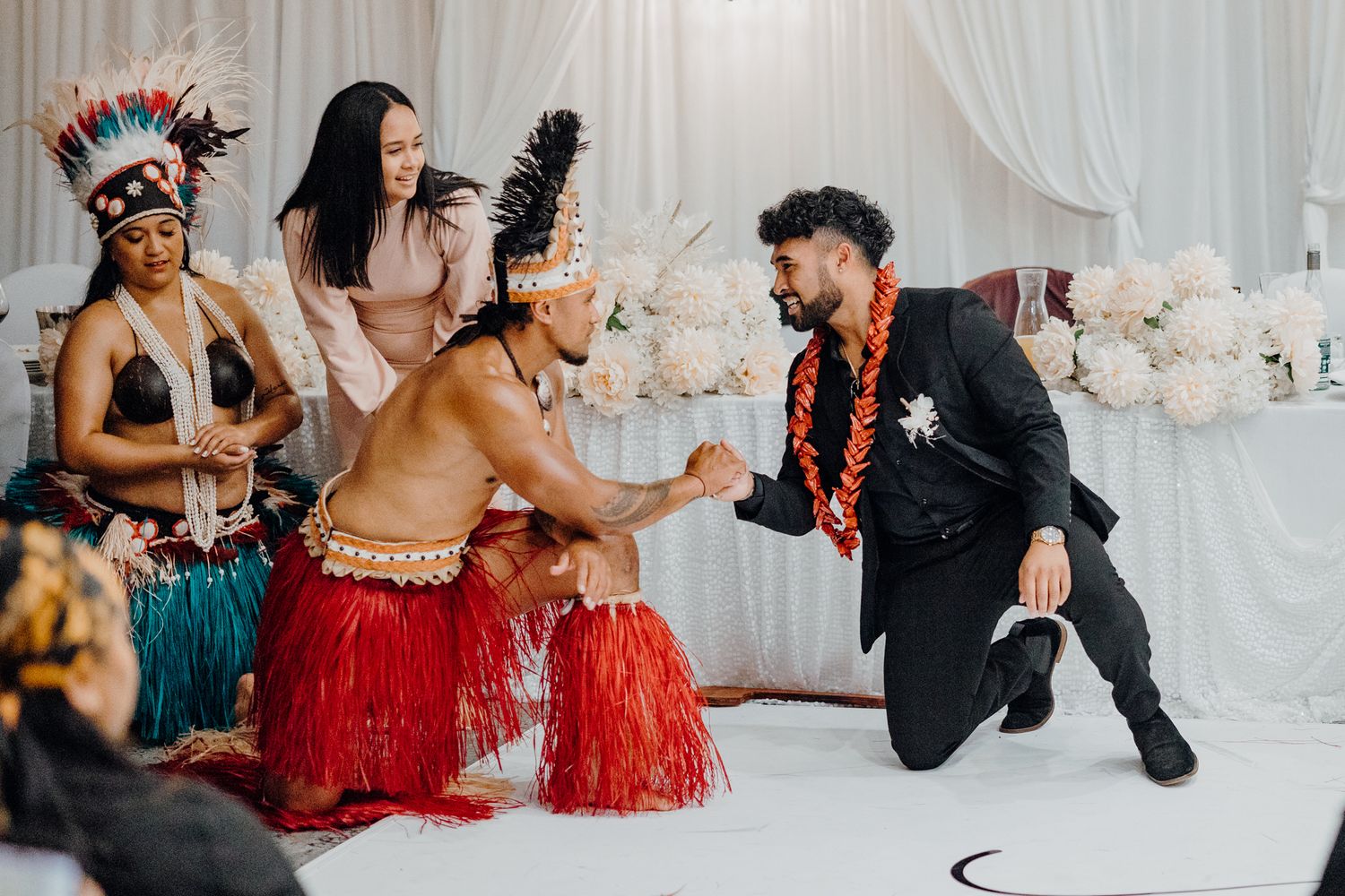 Dynamic cultural dance performance at wedding reception with traditional Polynesian costumes.