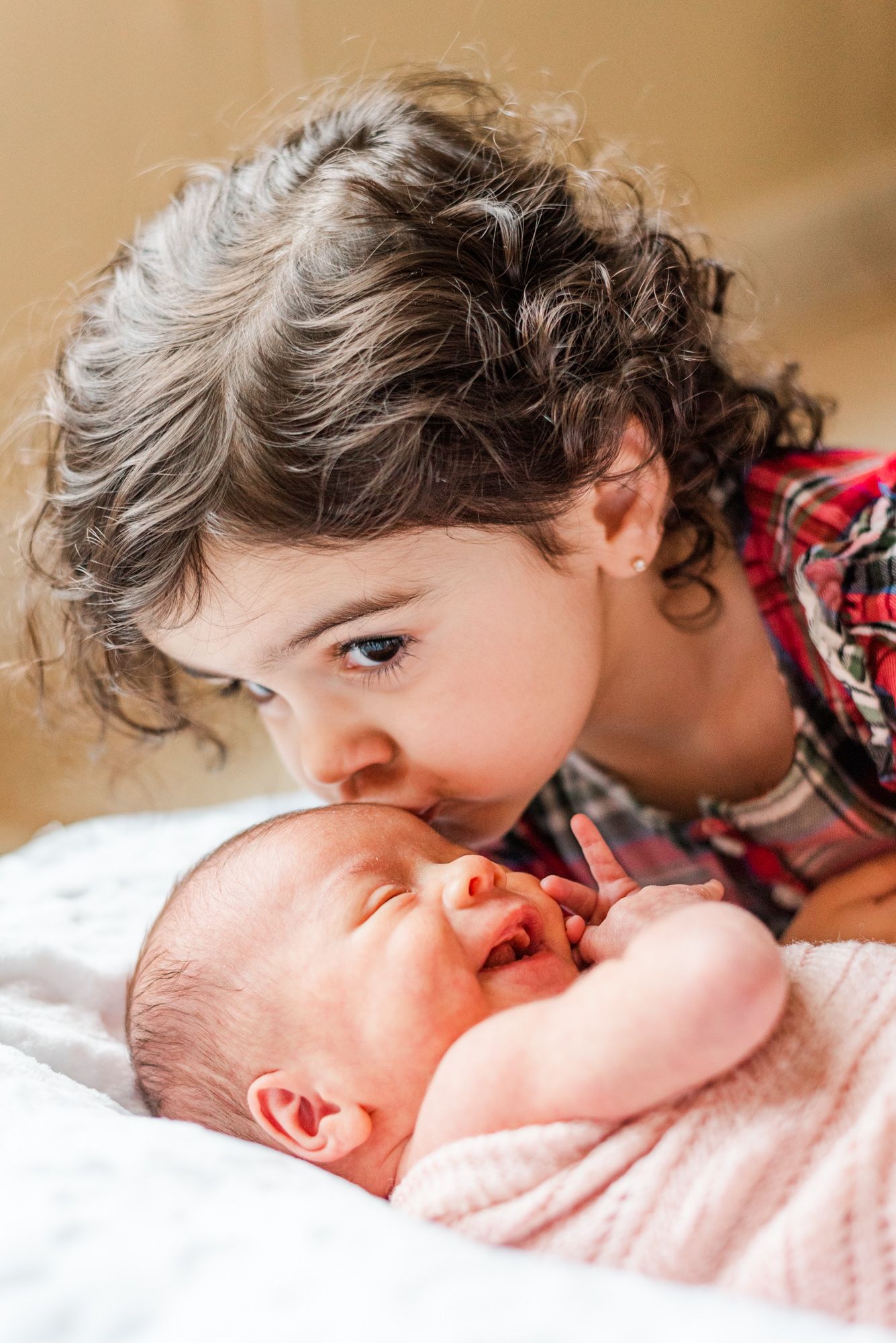 Lifestyle newborn baby in pink wrap with big sister in Pittsburgh, Pennsylvania