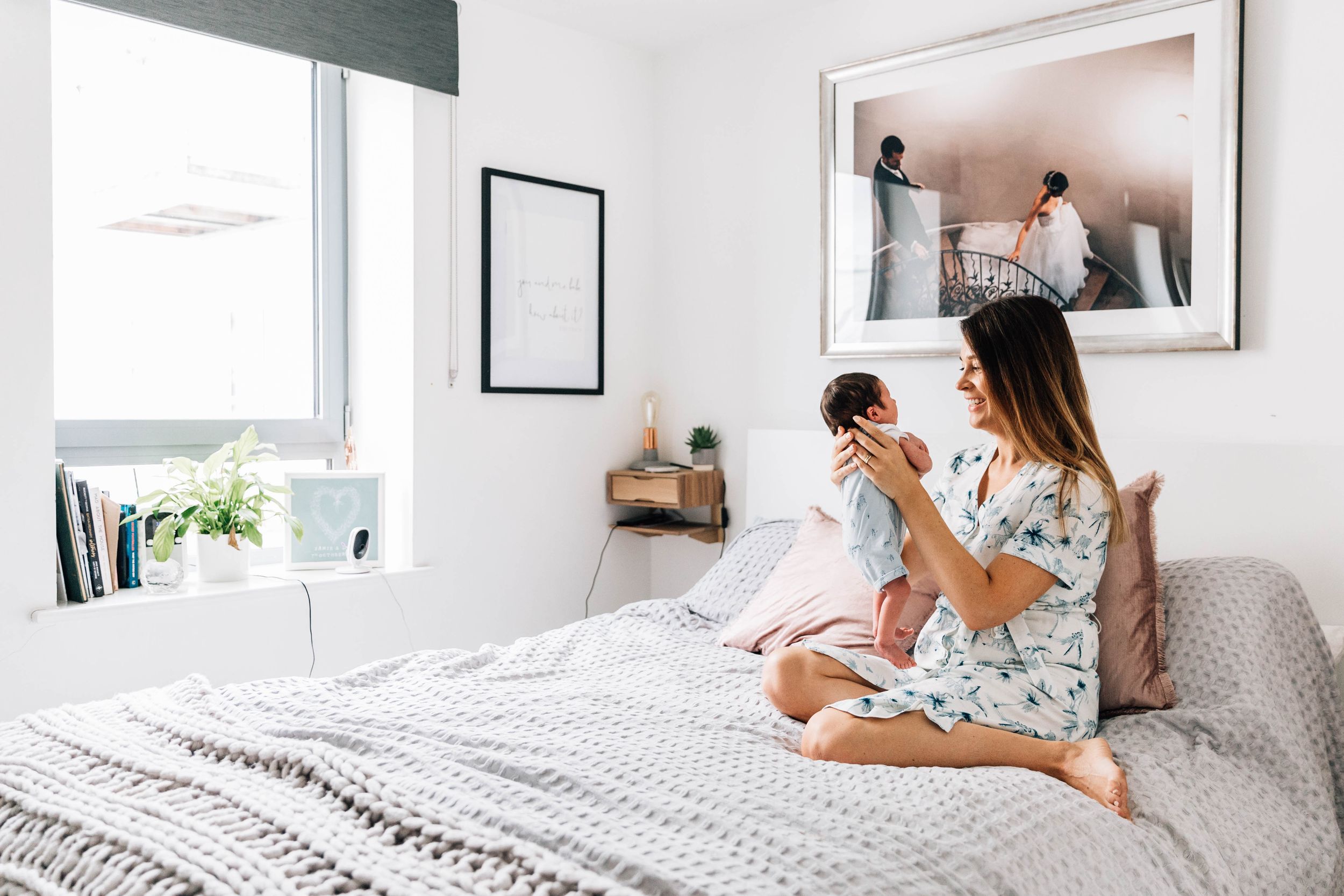 mum holding her baby on master bed