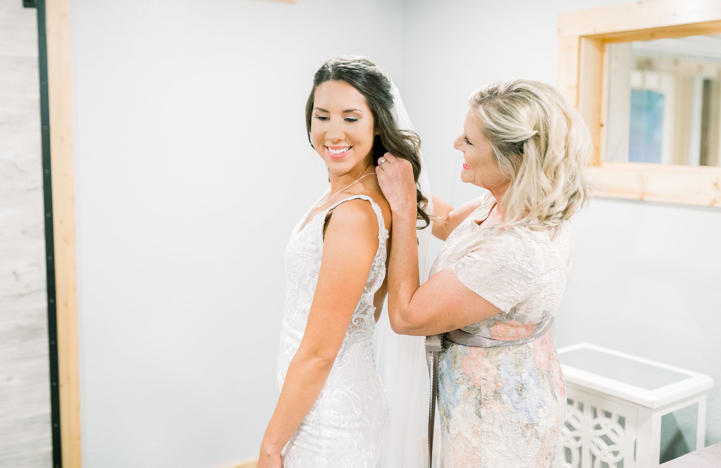 Getting ready dress zipping photos in at Prairie Moon Winery wedding in Ames, Iowa