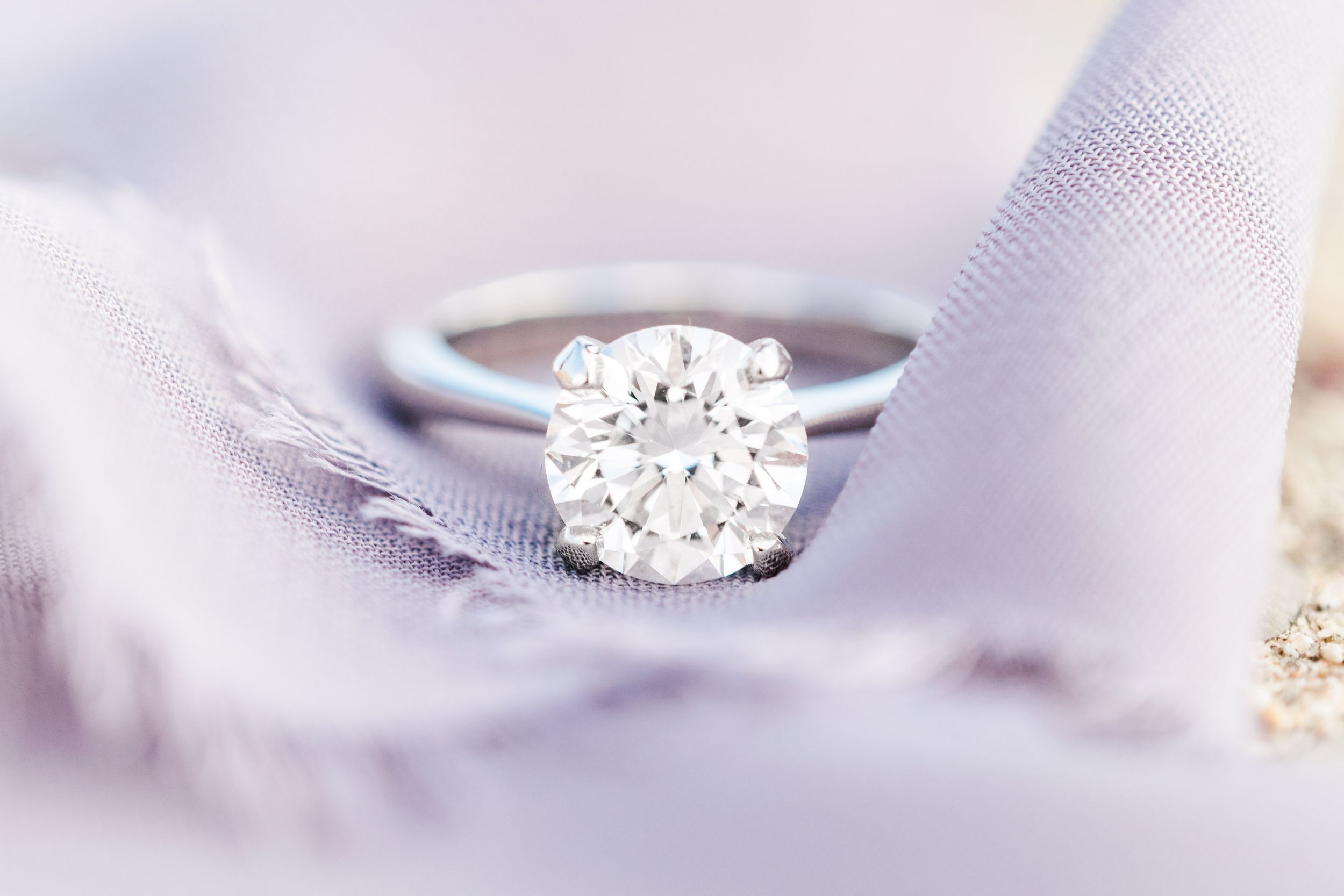 solitaire diamond engagement ring on purple ribbon