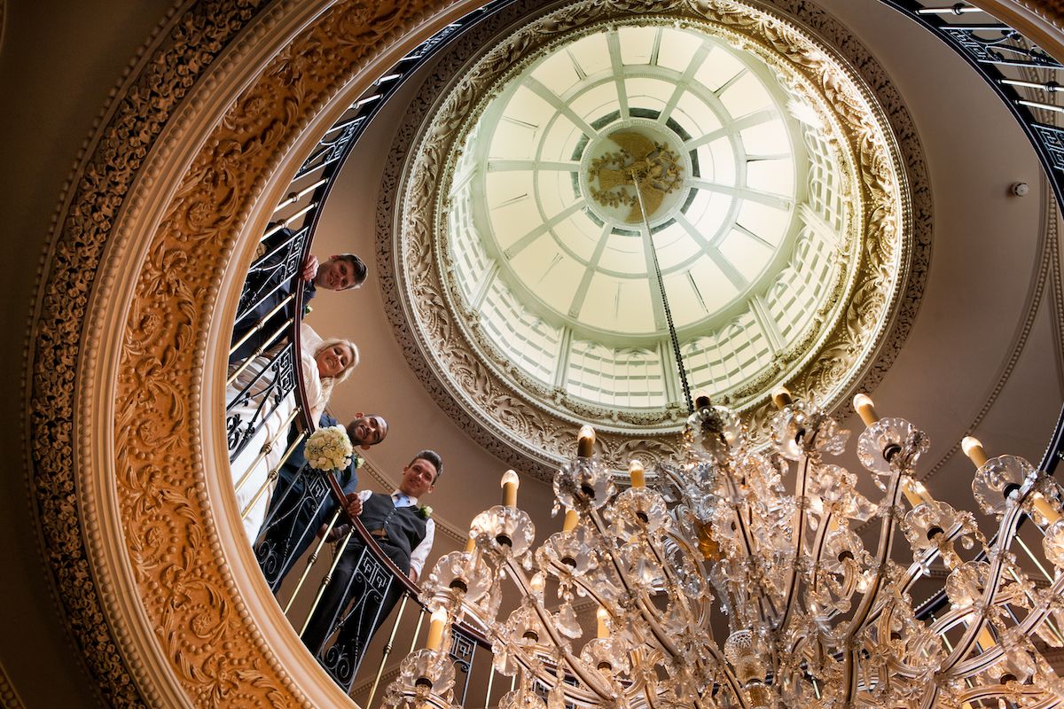 Bride and Groom looking down through a spiral staircase