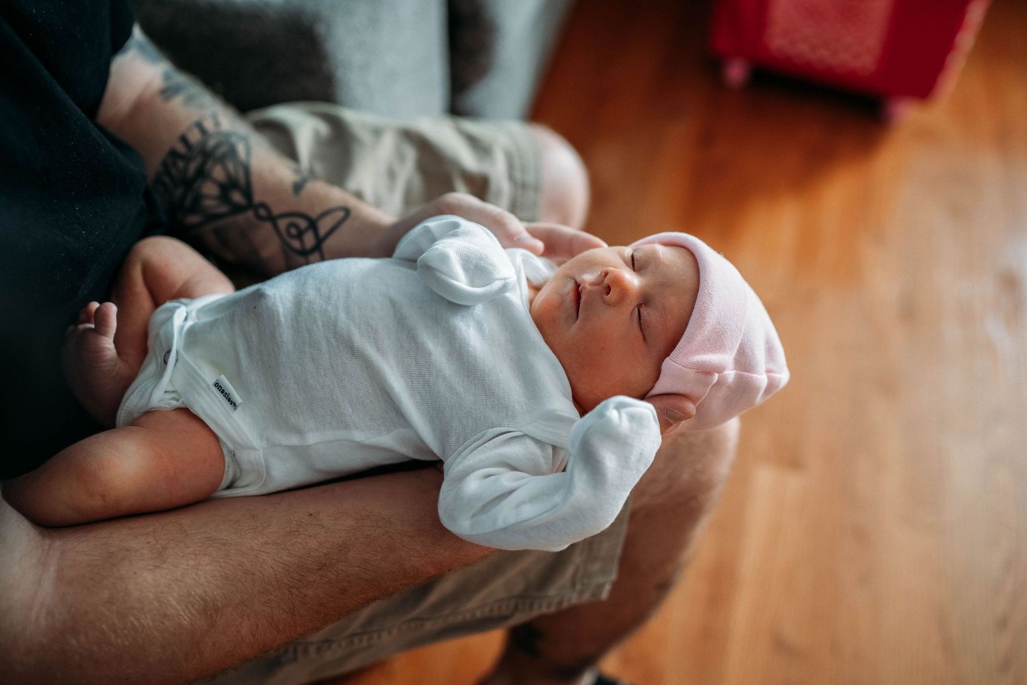 dad cradling newborn baby in his sudbury ma home