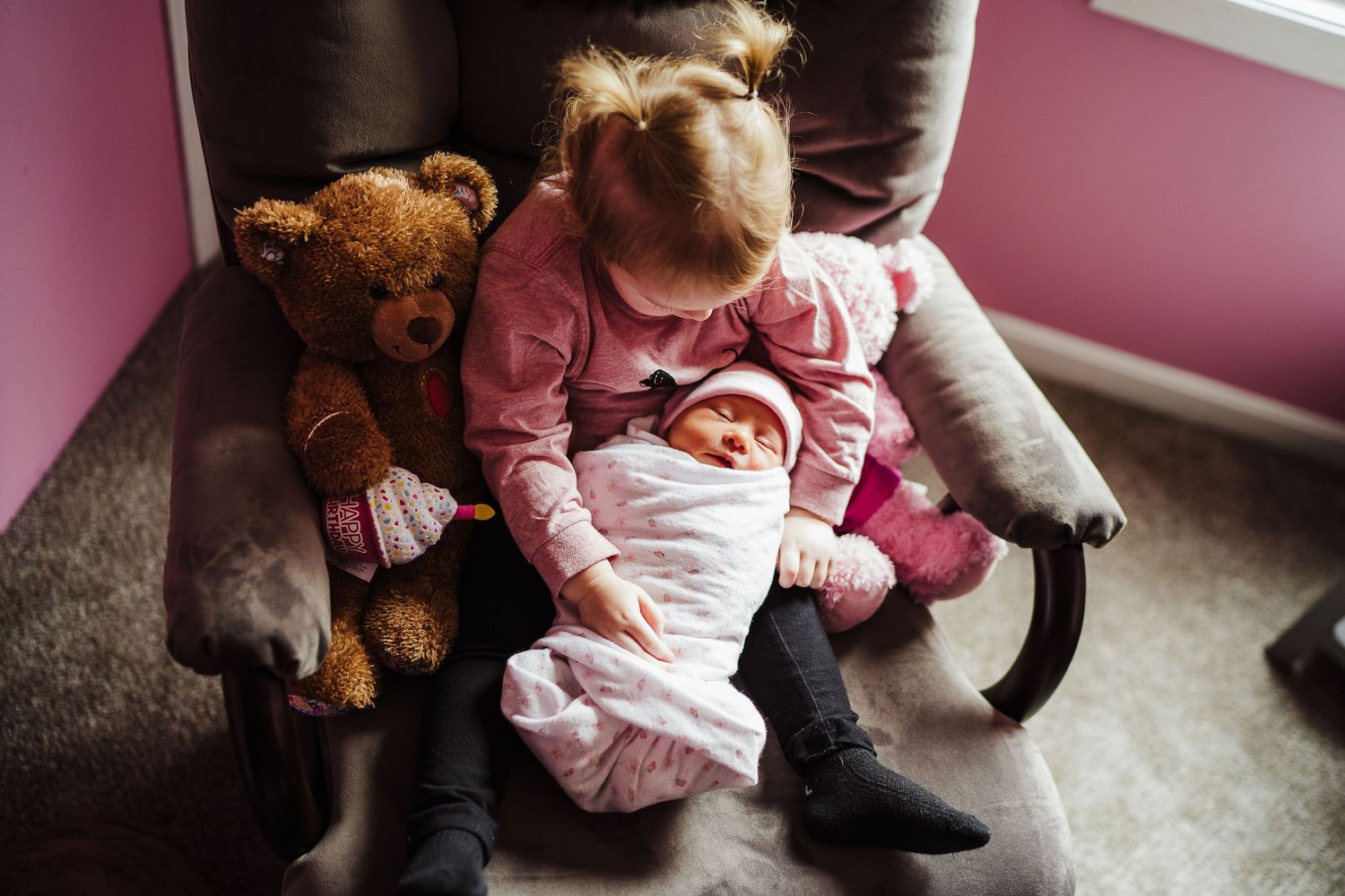 toddler holding her sister in a chair in sudbury ma home