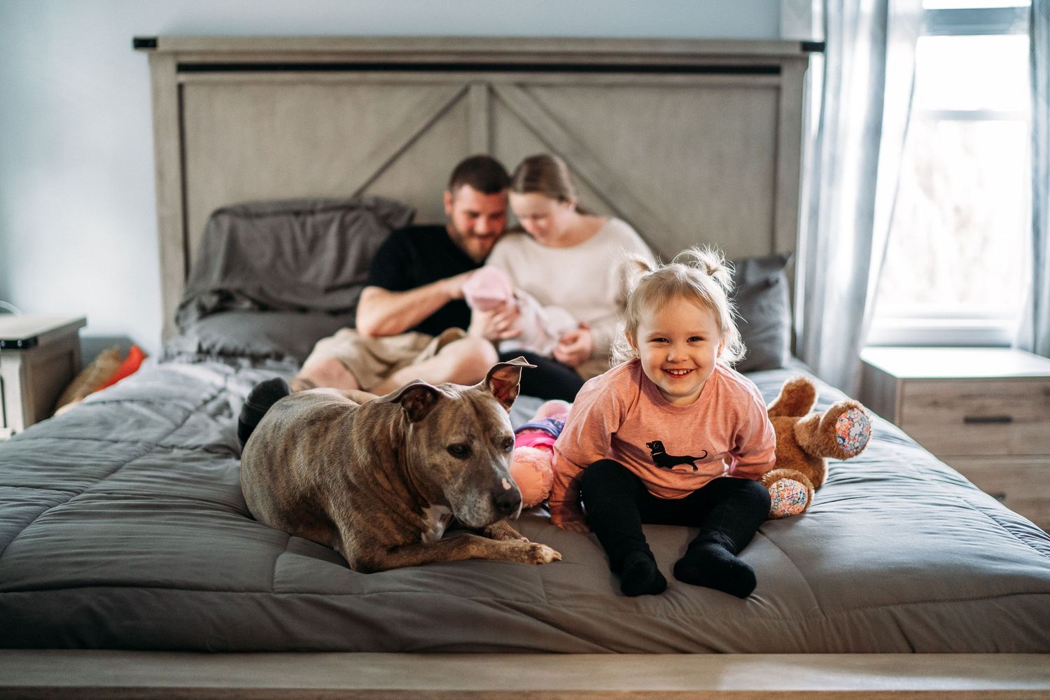 family snuggling on the bed in their sudbury ma homer