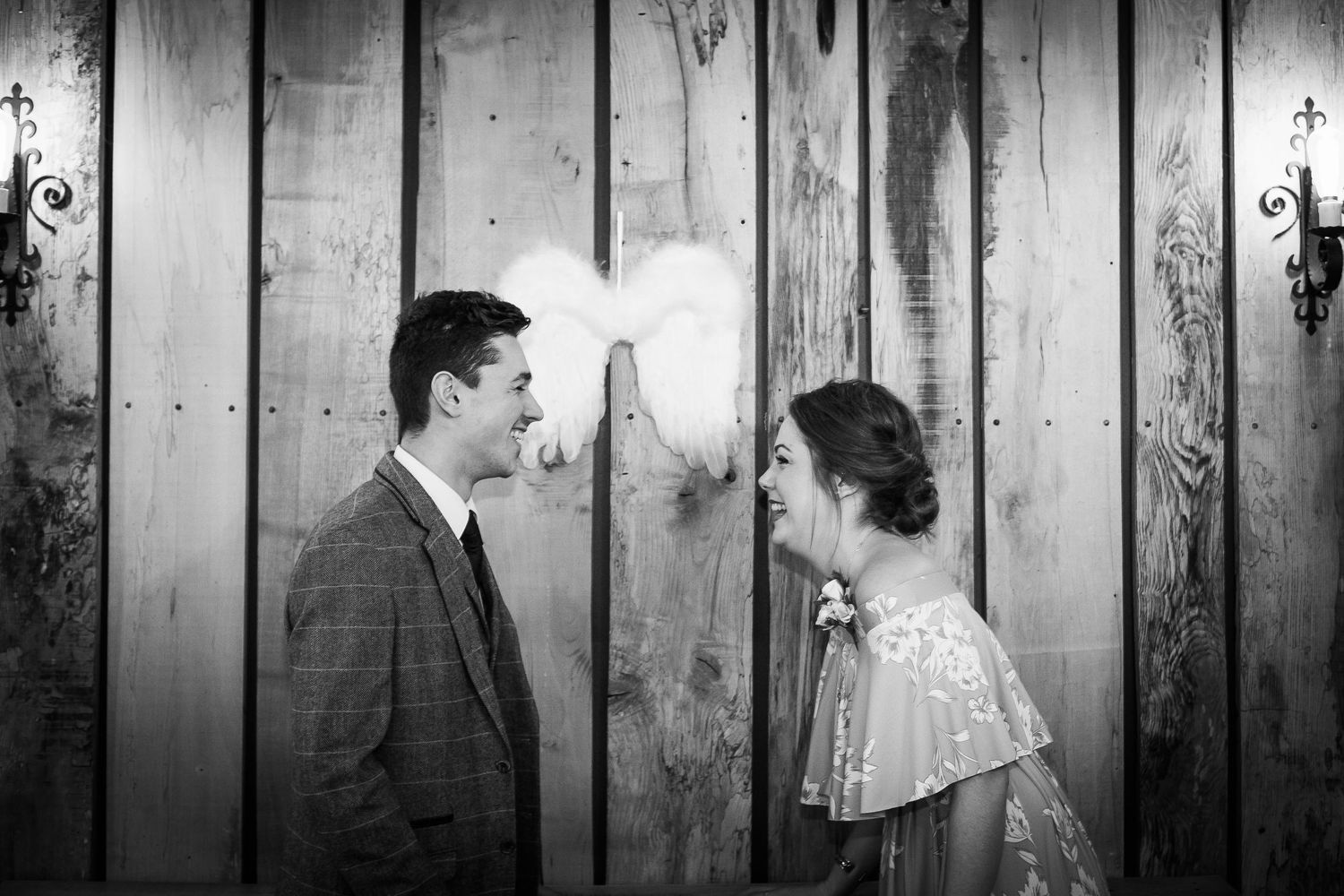 Couple laughing in front of angel wings at The Angel Pub