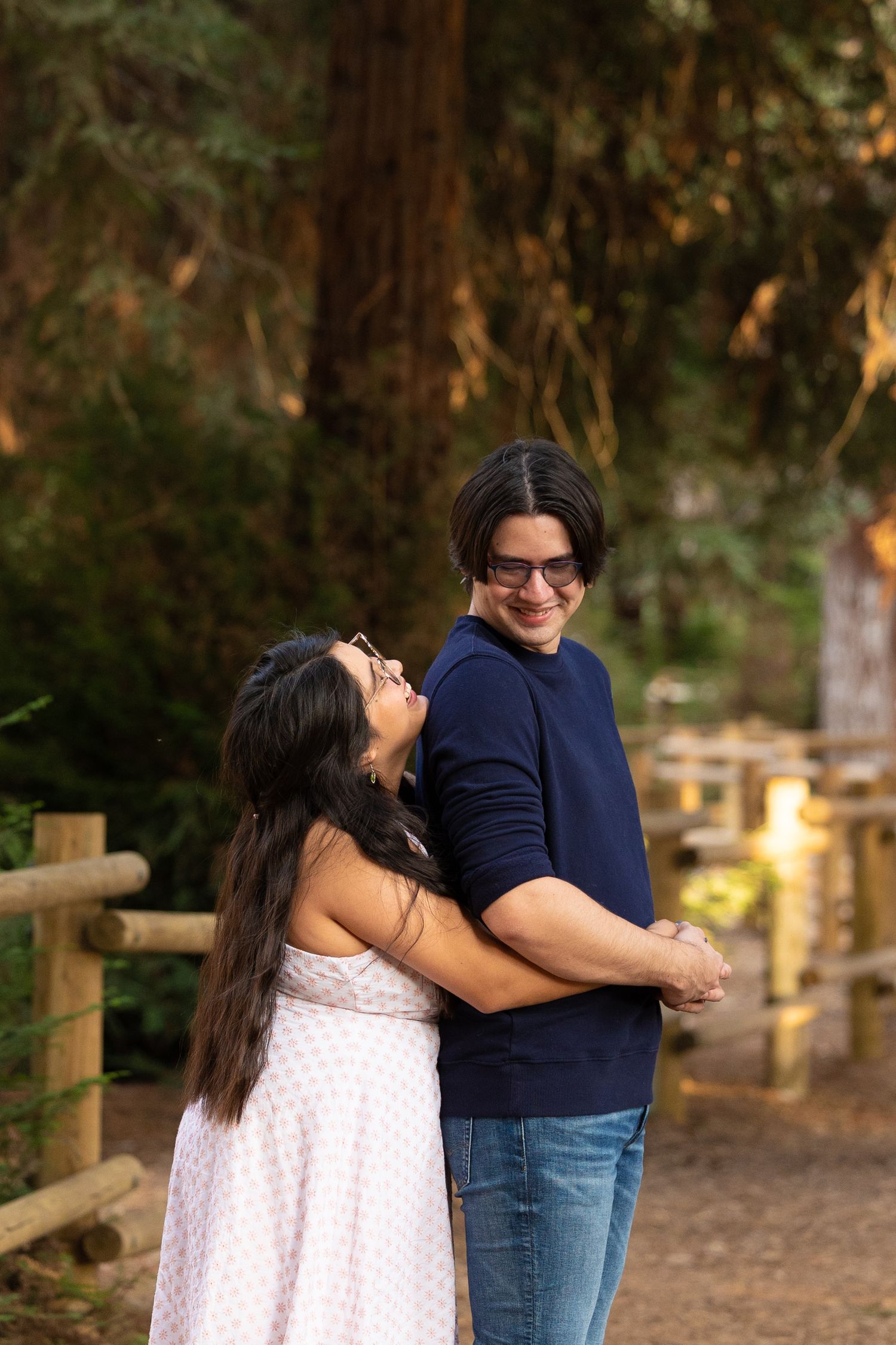 girl smiling and hugging fiance from behind