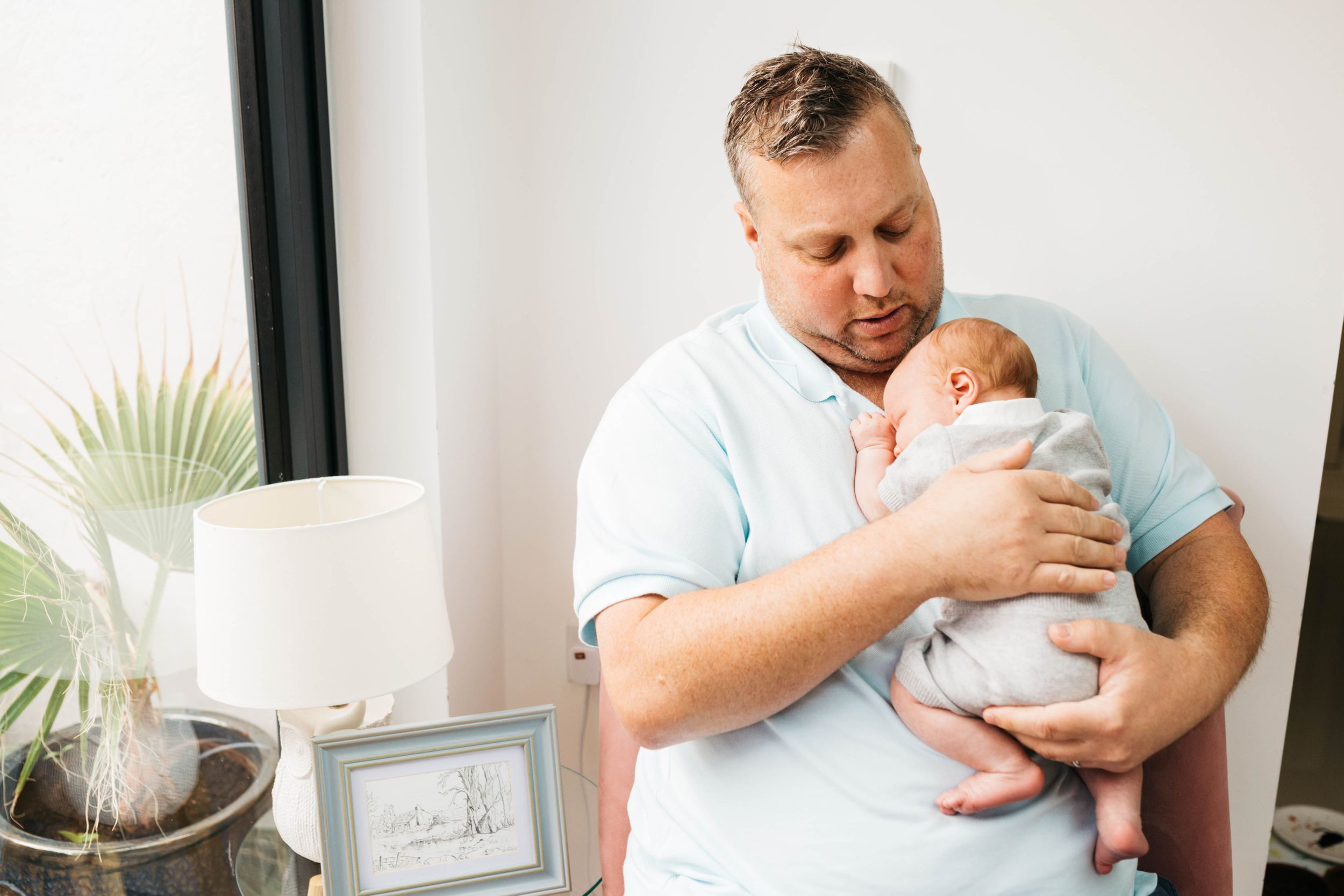 dad cuddling his newborn baby boy son