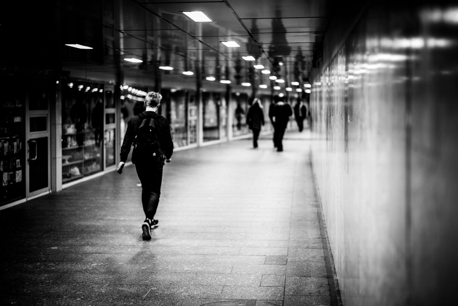 Black and white photo of young man walking underground in Moscow Russia