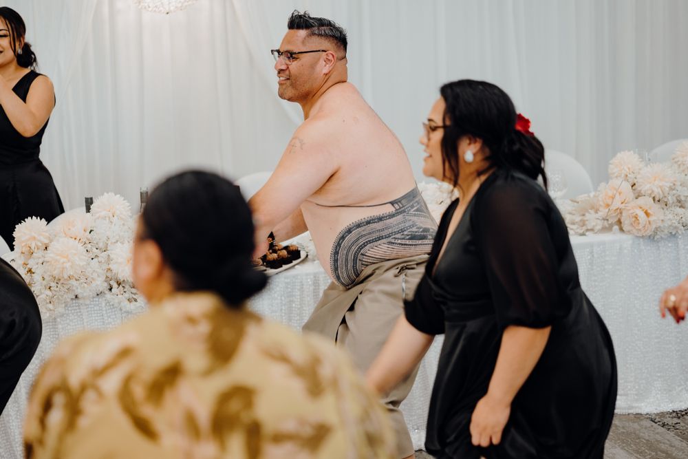 Wedding guests enjoying lively dance performances at indoor reception.