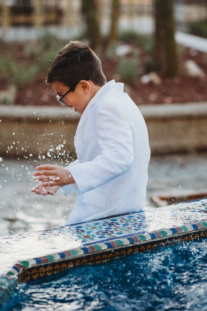 Portrait of a communion boy at a fountain