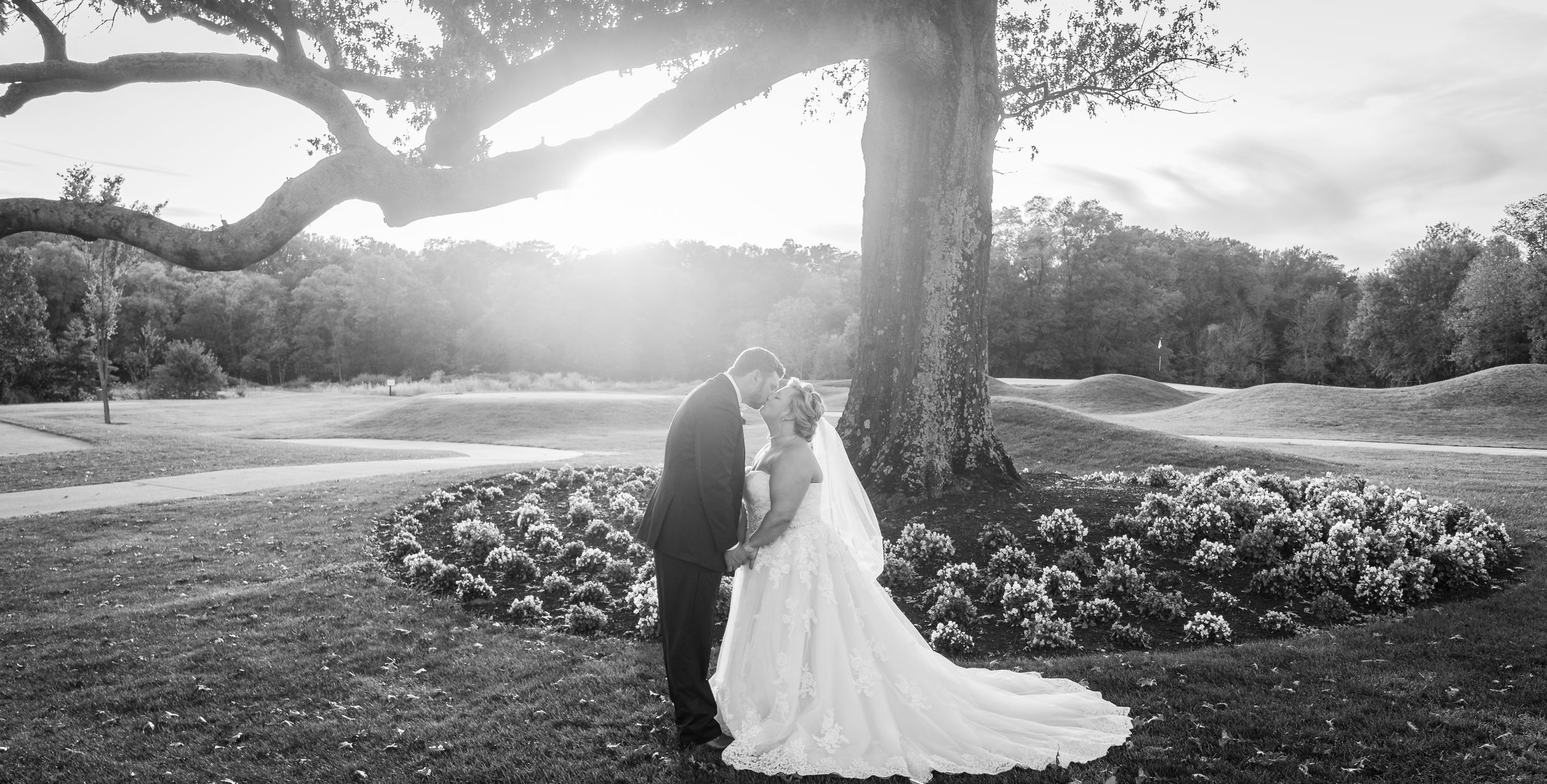 Bride and groom share a picturesque moment on the golf course, blending elegance with natural beauty.