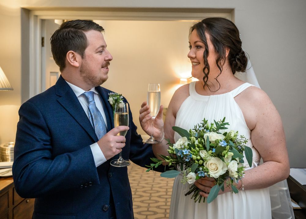 Bride and groom toast each other after elopement wedding at Storrs Hall