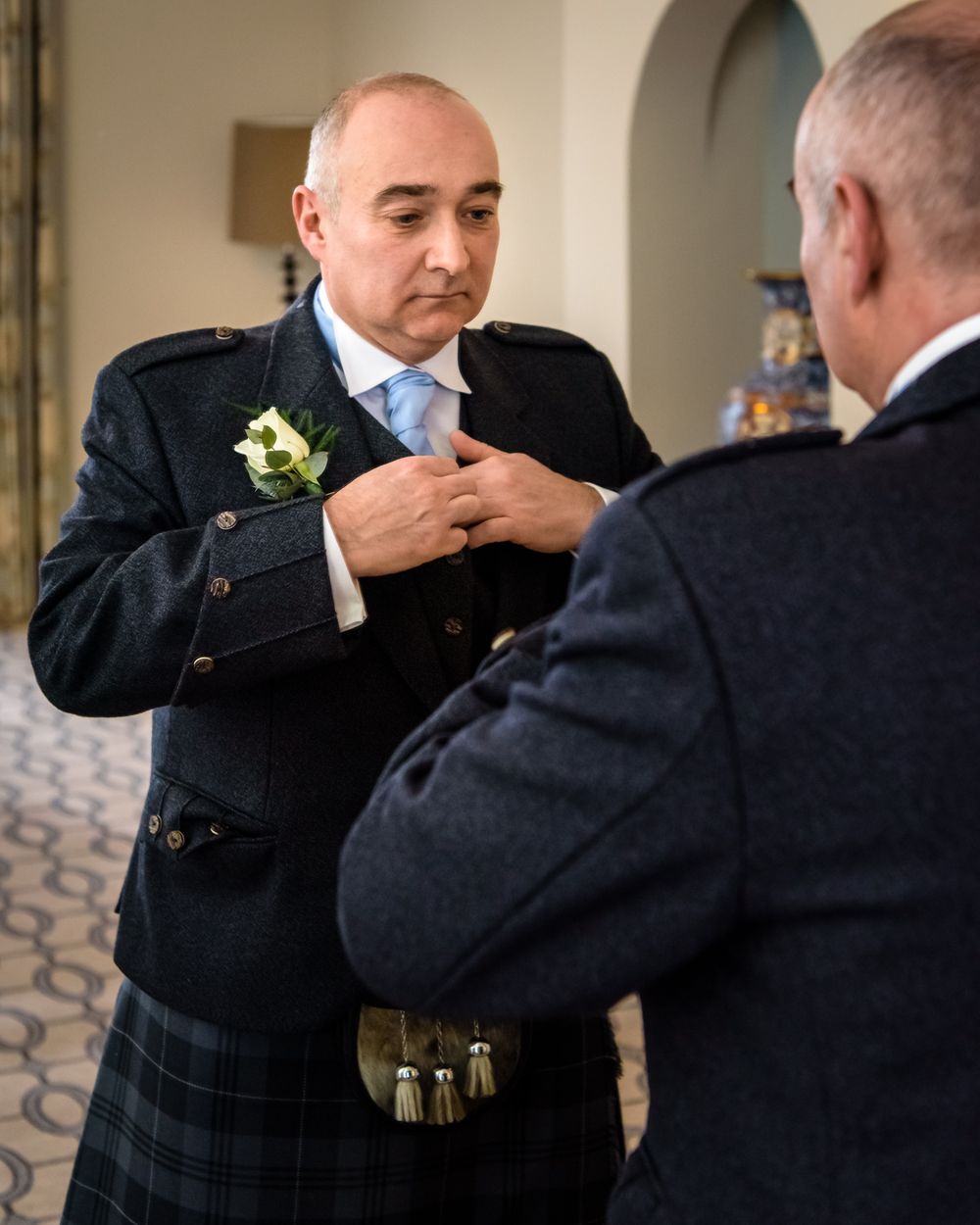 Groom in kilt adjusting his tie before Storrs hall wedding