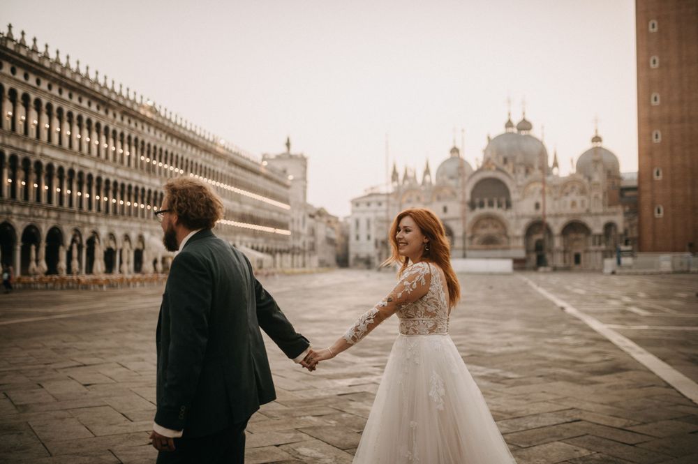 Wedding couple dancing in front of Basilica San Marco in Venice during golden hour.