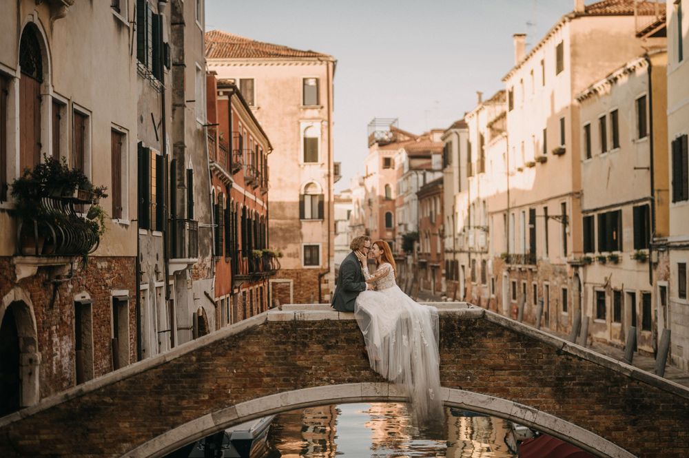 A scenic panorama of a quiet Venetian canal lined with historic buildings and bridges.