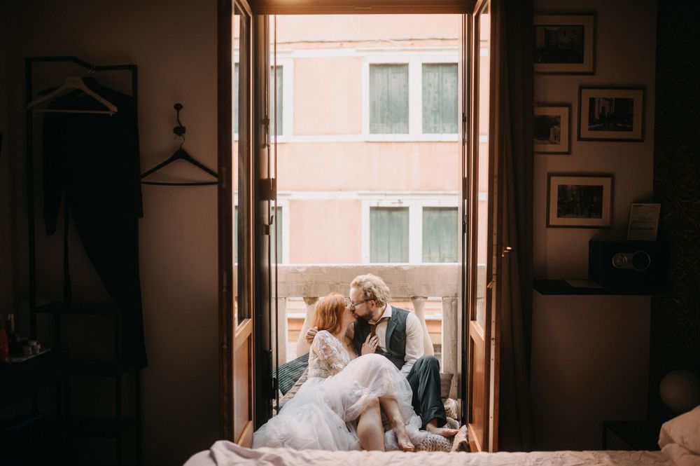 A warm, backlit wedding scene through a window in Venice.