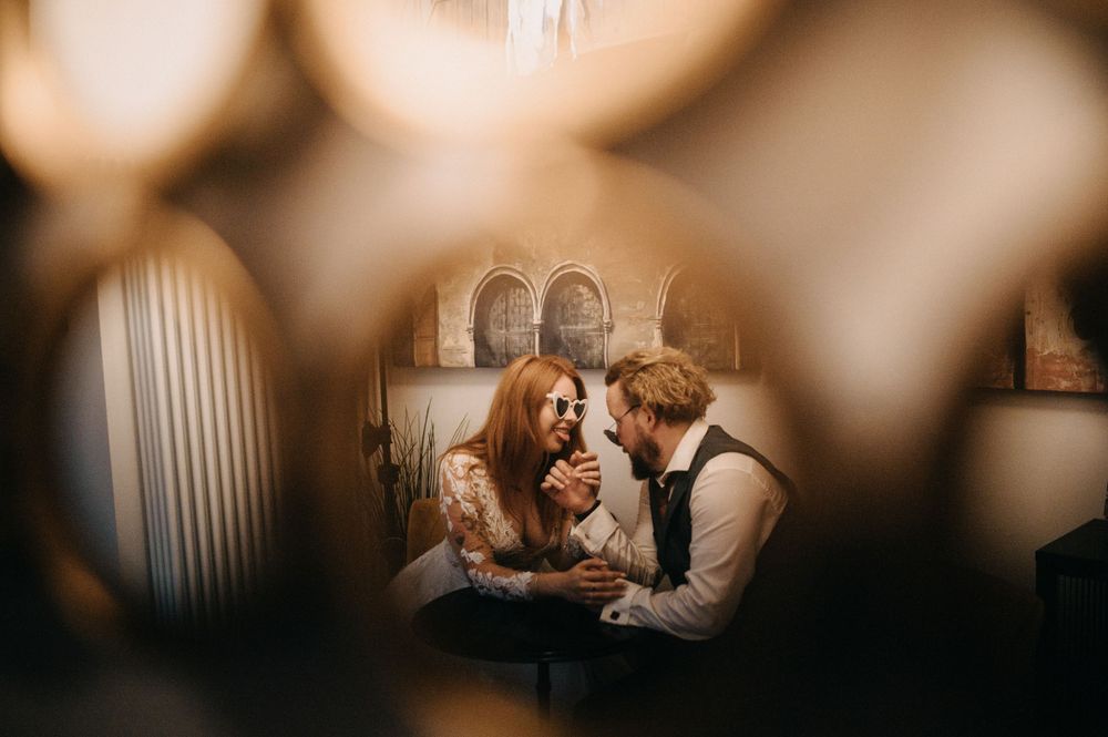 Romantic couple shares tender moment by window in soft morning light.
