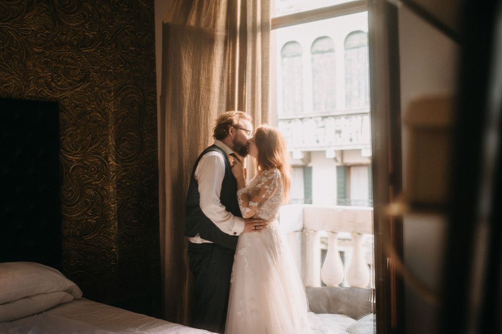 Romantic couple session by window with soft natural lighting and elegant styling.