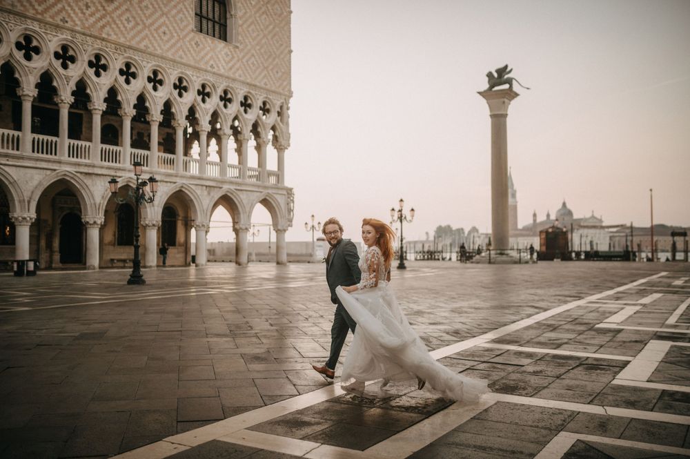 Panoramic view of St. Mark's Square with newlyweds dancing among historic architecture.