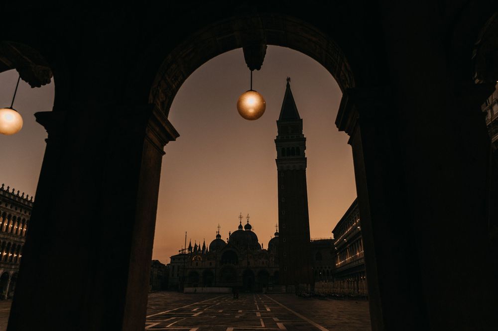 Silhouettes of architectural spires and domes against sunset sky.