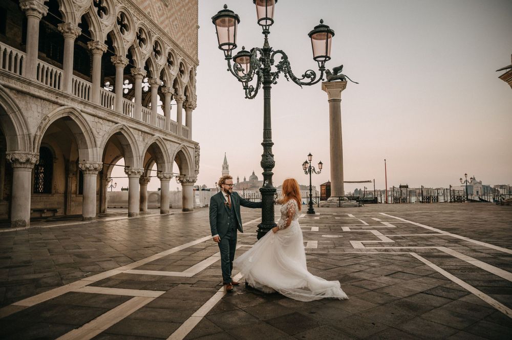 Elegant couple celebrating their wedding near the Doge's Palace columns in Venice.