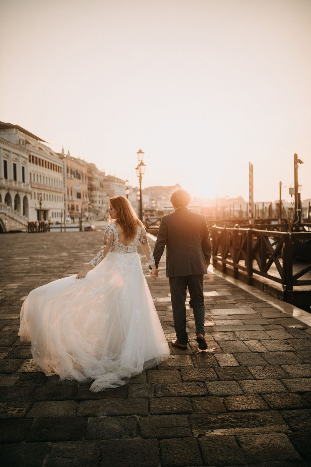 Romantic wedding photo session along Venice's historic waterfront during golden hour.