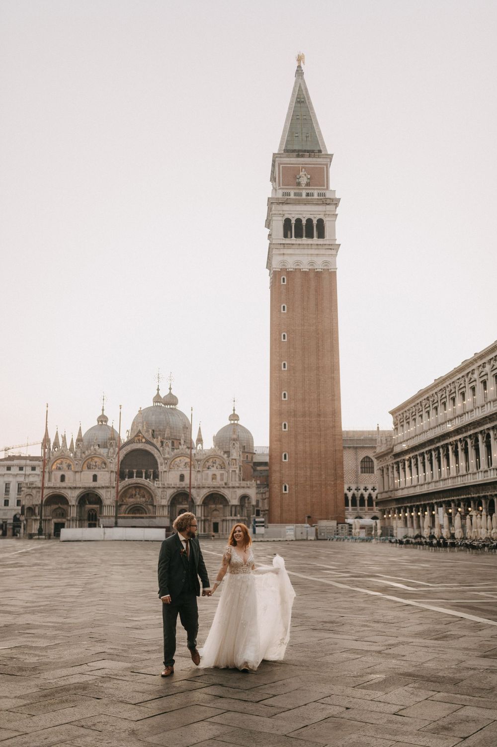 Walking through empty St Mark's Square in Venice with Basilica and campanile in view.