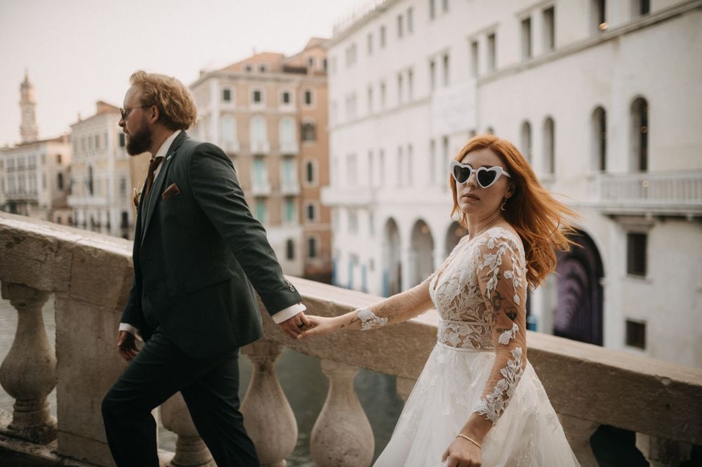 Wedding couple poses against Venice's classic stone buildings and archways.