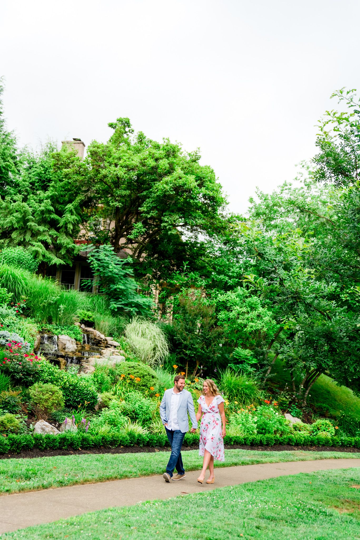 engaged couples in floral dress and light blue suit jacket and jeans walking in rainy Louisville