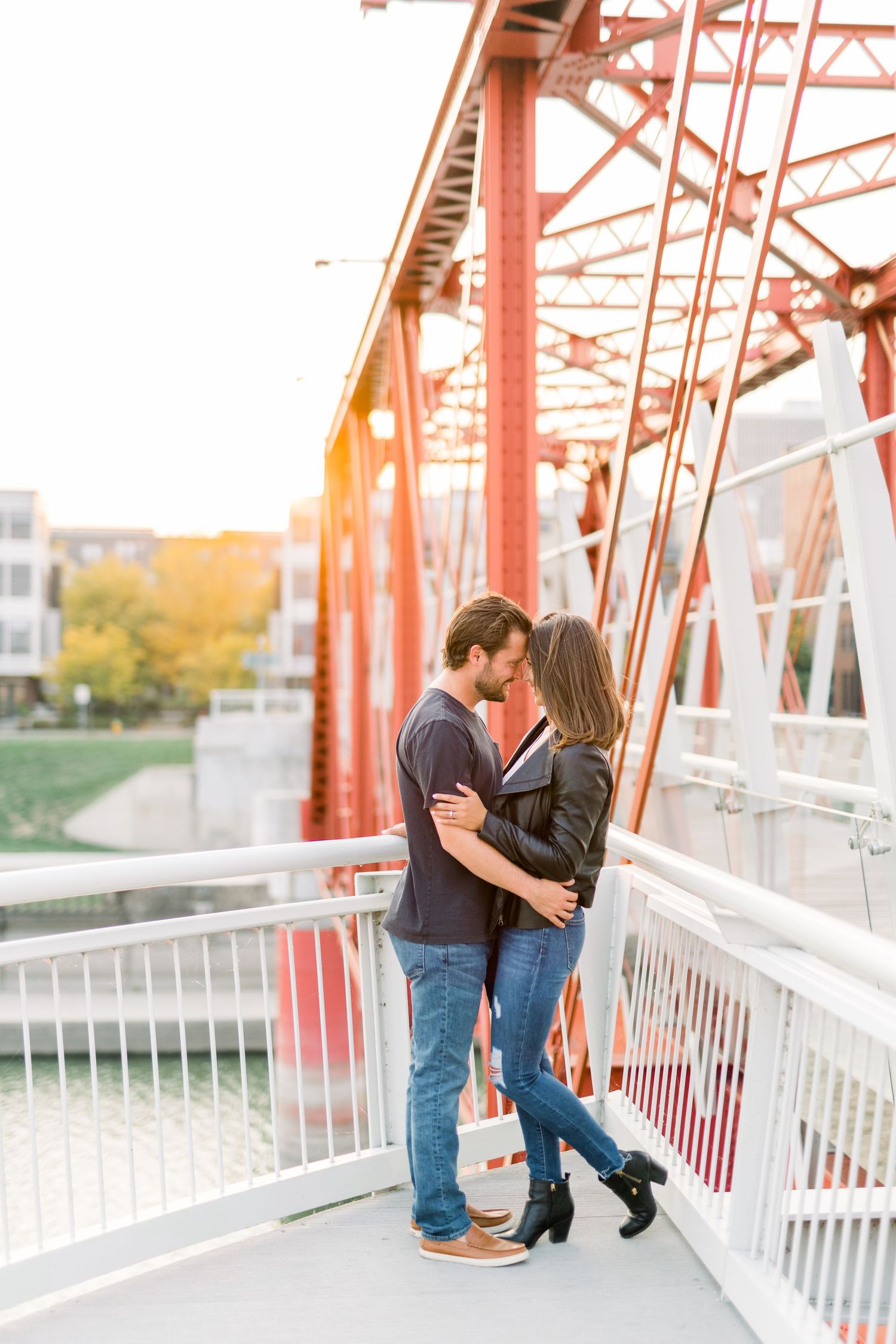 Des Moines Engagement photos on red bridge in downtown Des Moines, Iowa with light and airy photographer Nicole Laing