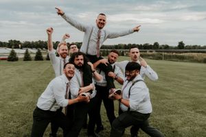 Finger Lakes Groomsmen with groom on their shoulders posing like they won the Superbowl