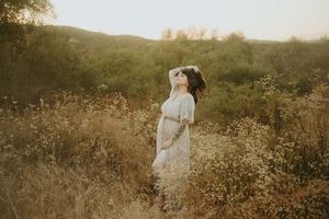 Maternity photoshoot by Tiffany Kelterer, photographer in San Diego of woman standing in flowers Ramona Grasslands