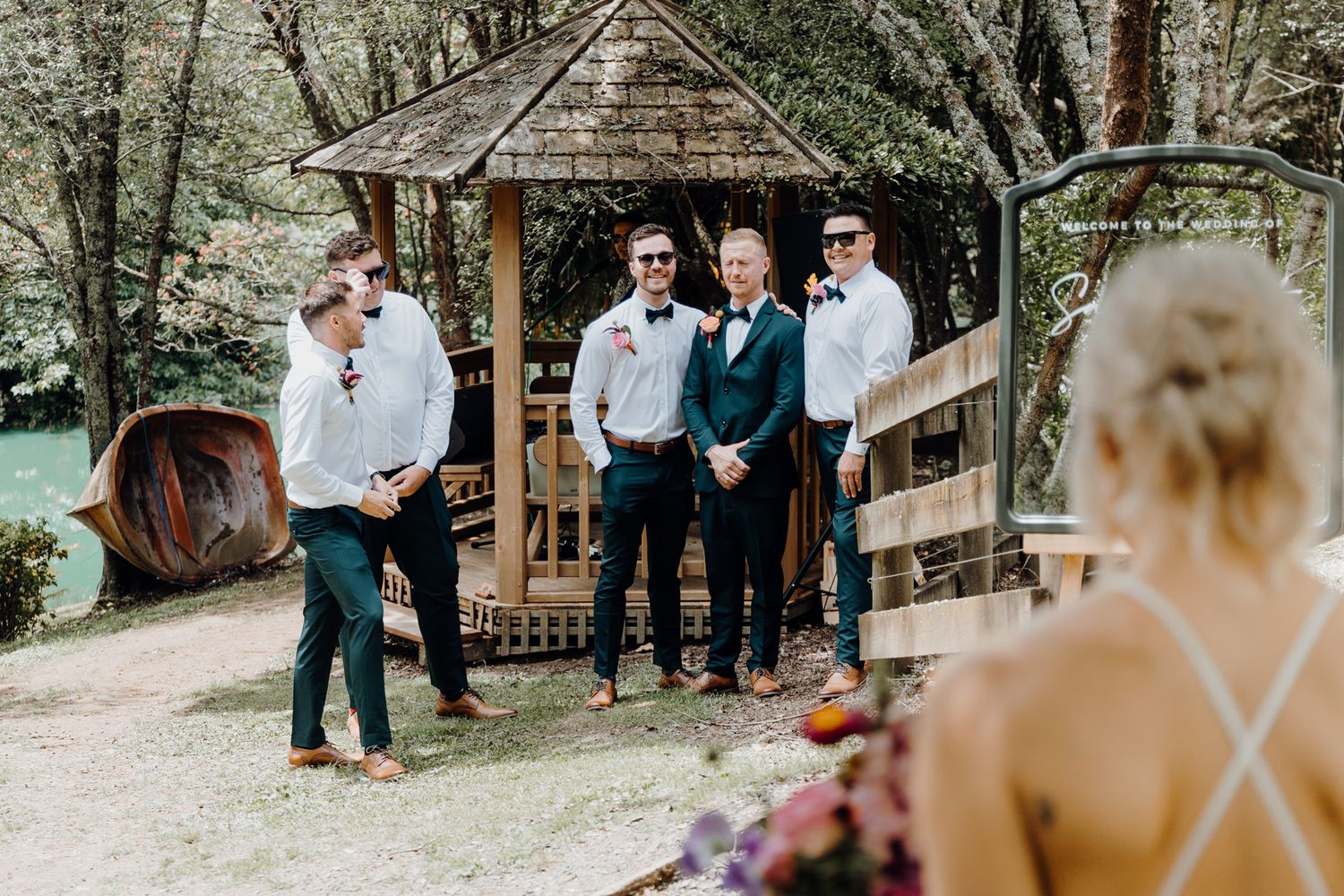 Wedding photo session taking place at a rustic wooden gazebo in a garden setting.