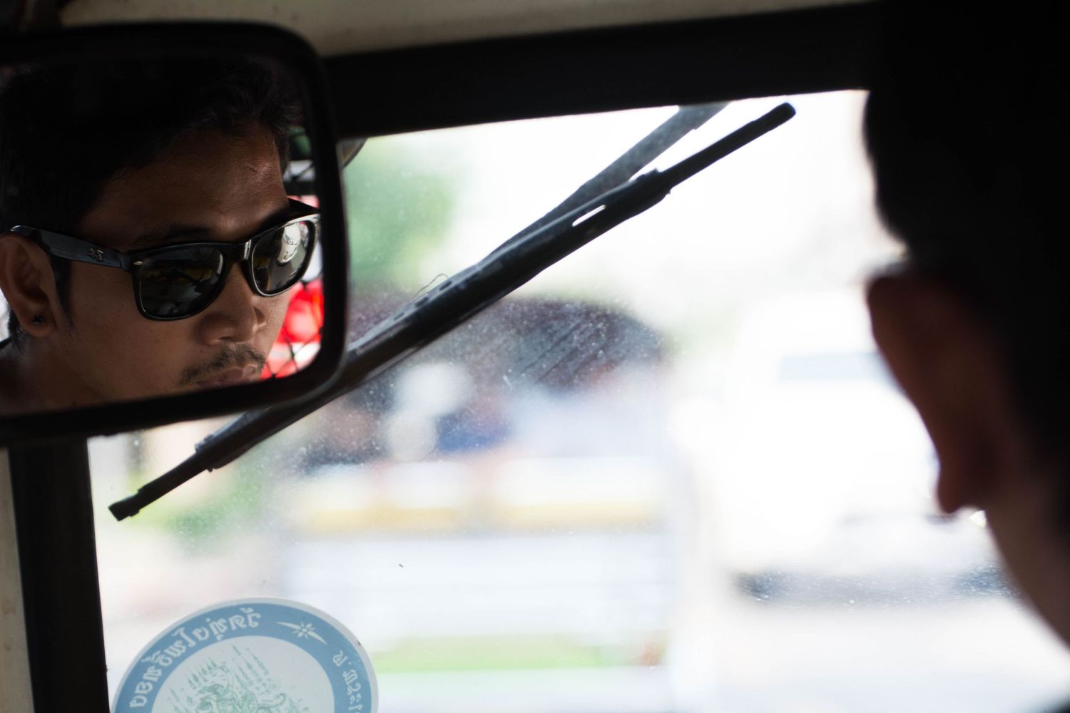 Environmental portrait of tuk-tuk (Auto rickshaw) driver, taken from back seat