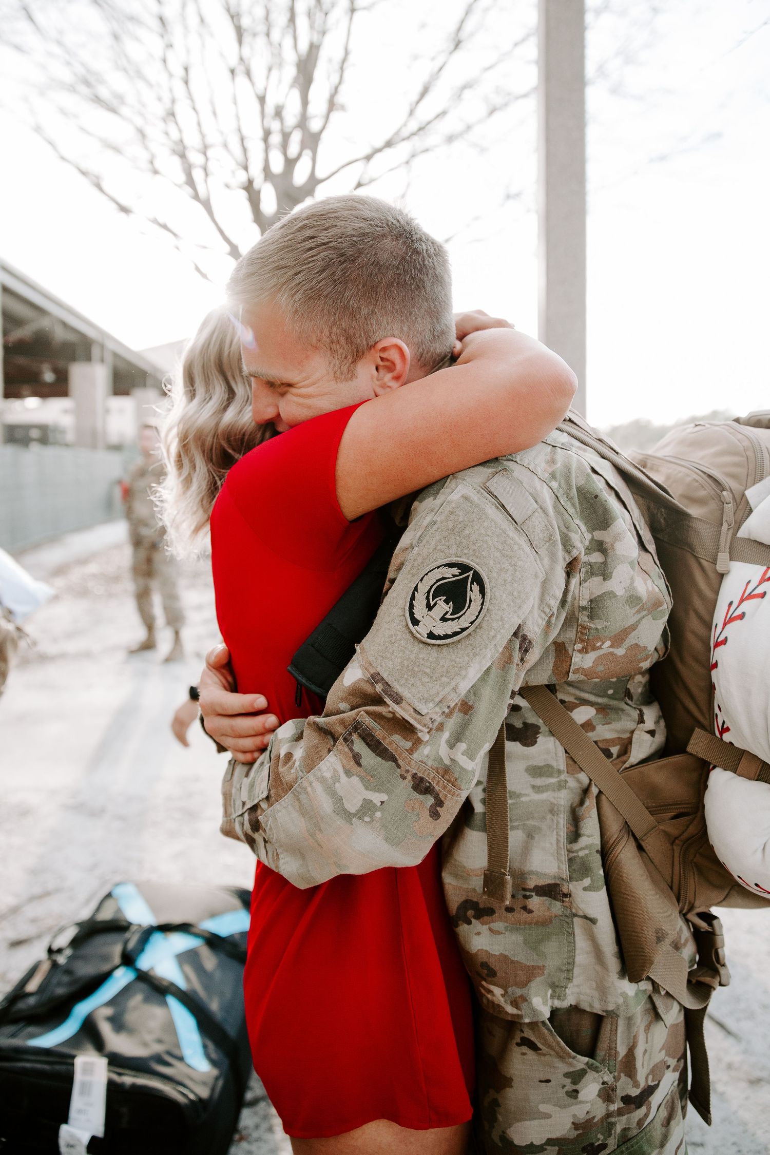wife and husband hugging each other as he is in his Air Force uniform