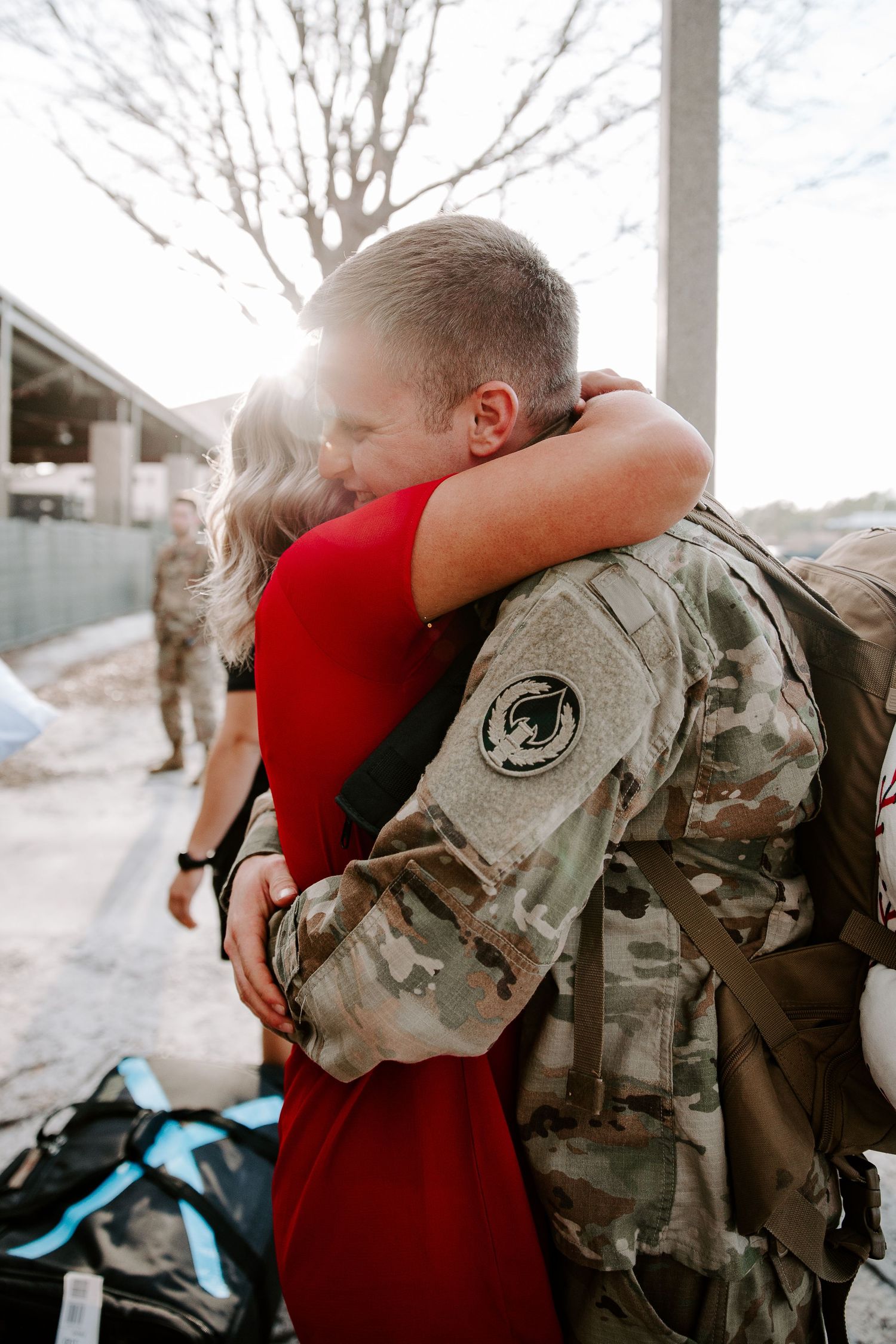 man smiling as he is hugging his wife after his deployment