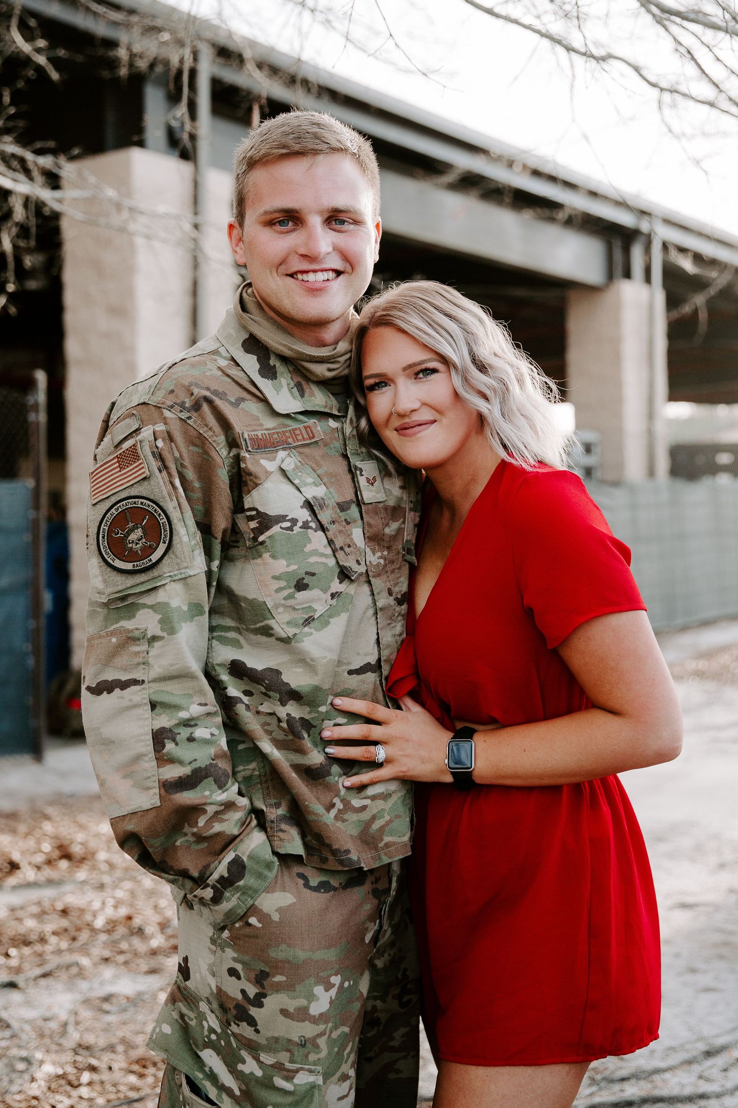 couple smiling with their arms around each other during a weekend military homecoming