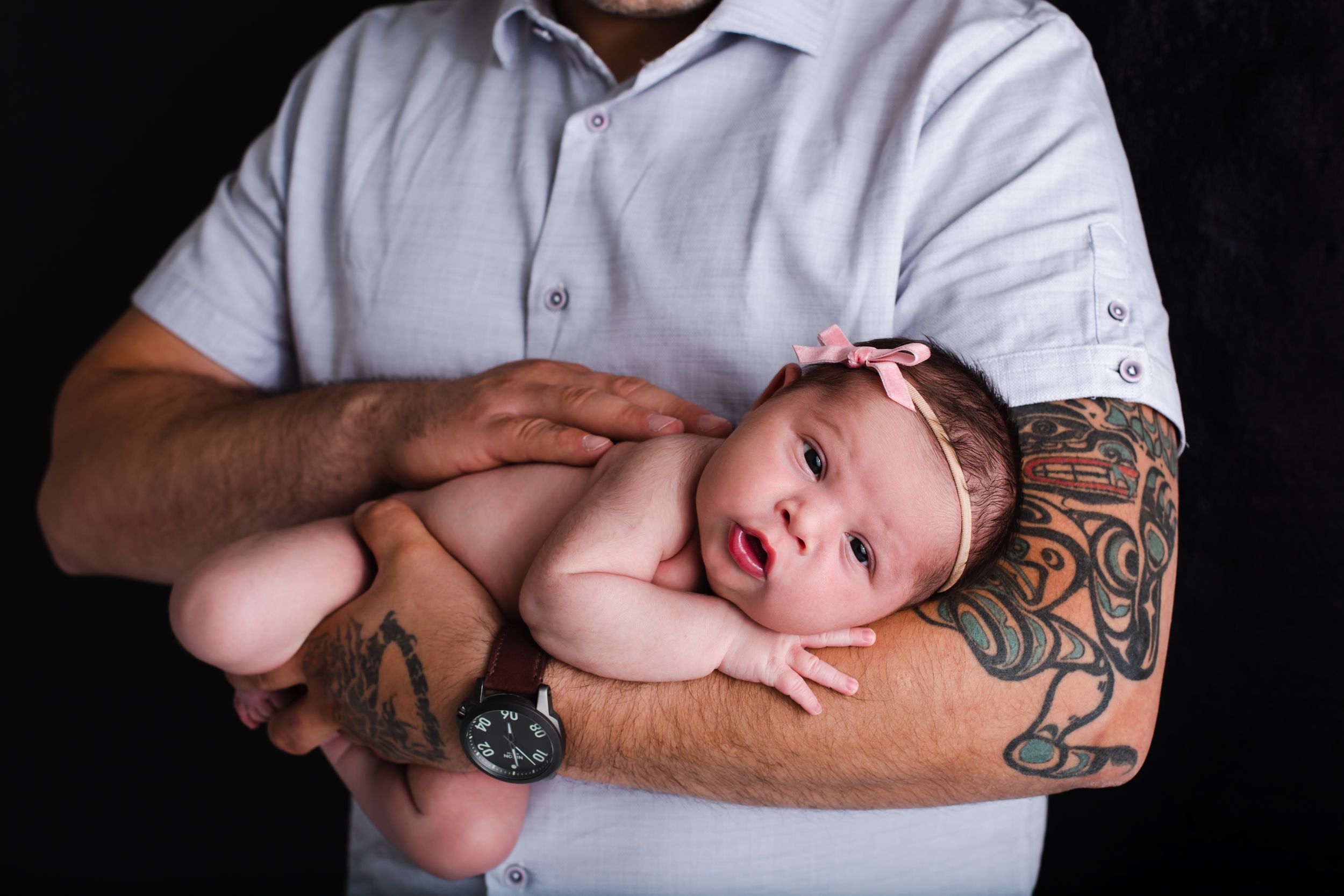 Newborn baby laying in daddy's arms for newborn picture in Penticton BC