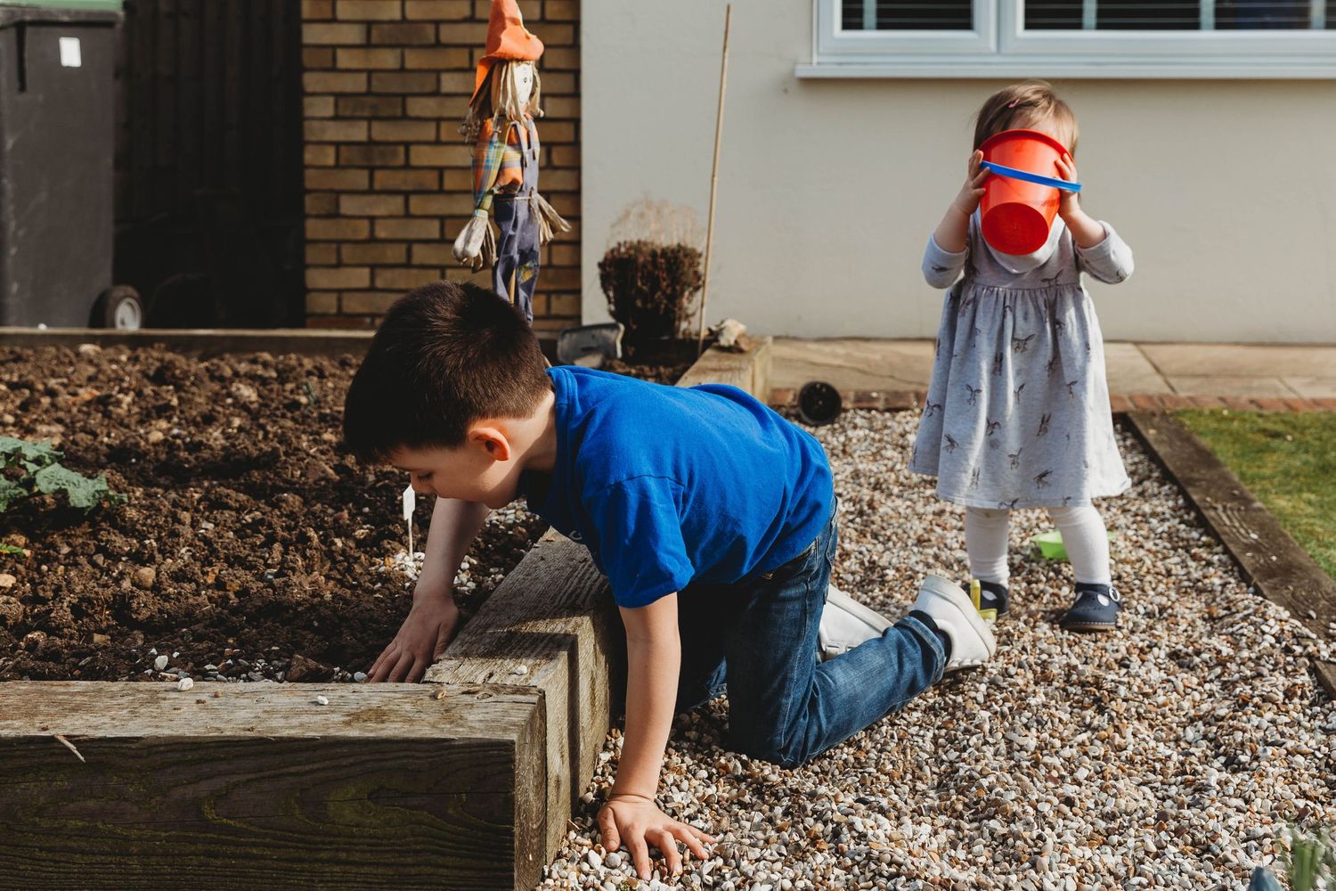 kids playing with pebbles in garden