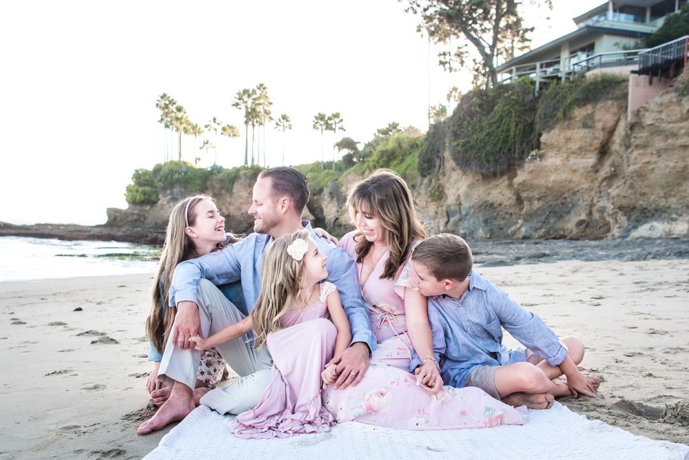 Family sitting on a beach in Laguna Beach, CA