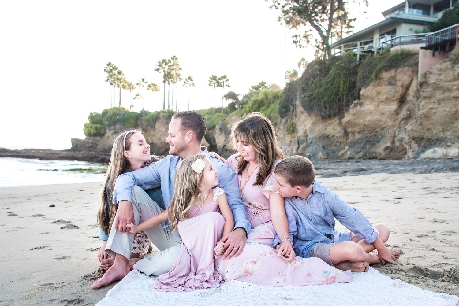 Family sitting on a beach in Laguna Beach, CA