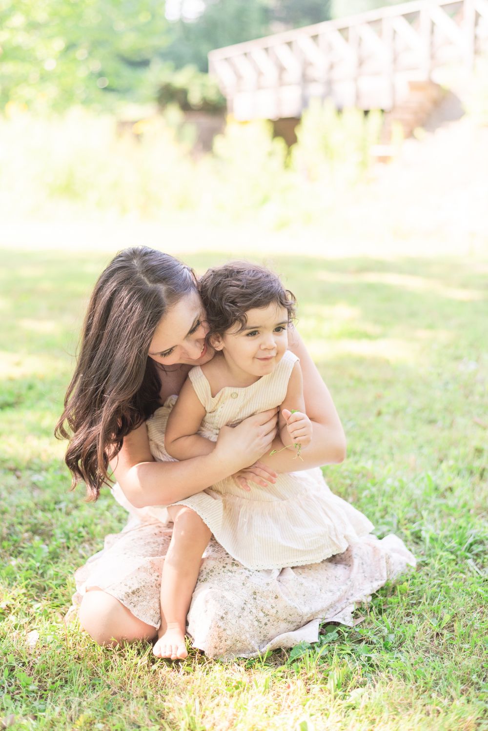 Mom and daughter hugging in grass in Pittsburgh, Pennsylvania
